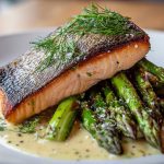 A restaurant-quality plate of pan-seared salmon with crispy skin, served on a bed of tender-crisp asparagus and finished with fresh dill.