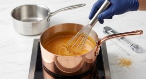 A hyper-realistic close-up of a gleaming copper saucepan filled with shimmering golden caramel being stirred by a whisk. A digital thermometer and sugar crystals rest on a white marble counter, with a blurred stainless steel pot in the background, conveying culinary precision.