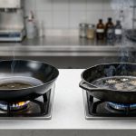 A high-contrast, photorealistic studio comparison of two skillets. On the left, a sleek carbon steel skillet with a uniformly deep black, mirror-like seasoning shows even heat. On the right, a rugged cast iron skillet has patchy seasoning and inconsistent heating with visible hot spots.