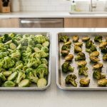 A top-down shot of two identical bare aluminum baking sheets on a light kitchen countertop. On the left, a sheet is overcrowded with pale green, unappetizing, soggy broccoli florets and halved Brussels sprouts, with a hint of steam. In stark contrast, the sheet on the right displays the same vegetables meticulously spaced, beautifully golden brown, deeply caramelized, and crispy, exuding a delicious, roasted quality. Bright, natural lighting highlights the dramatic textural and color differences.