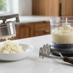 A highly detailed, photorealistic image contrasting two mashed potato preparations on a clean kitchen counter. On the left, a ricer extrudes a delicate, fluffy mound of bright white, airy mashed potatoes. On the right, a food processor yields dense, grayish, gluey, pasty mashed potatoes in a bowl, with a hand masher nearby.