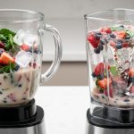 Two transparent blenders, side-by-side, illustrating blending efficiency. The left, with a round pitcher, shows smoothie ingredients circling inefficiently at the edges with a weak central vortex and unblended chunks. The right, with a square pitcher, displays the same ingredients powerfully drawn into a deep, strong vortex, actively blending everything.