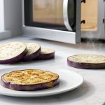 A photorealistic still life showing the culinary transformation of purple eggplant: raw slices, a steaming pre-treated slice, and a perfectly pan-fried, non-oily slice on a white plate, with a microwave in the background.