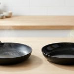 A photorealistic image shows a degraded nonstick skillet with an aerosol spray on the left, contrasted with a pristine skillet receiving oil from a modern mister on the right, on a clean kitchen counter.
